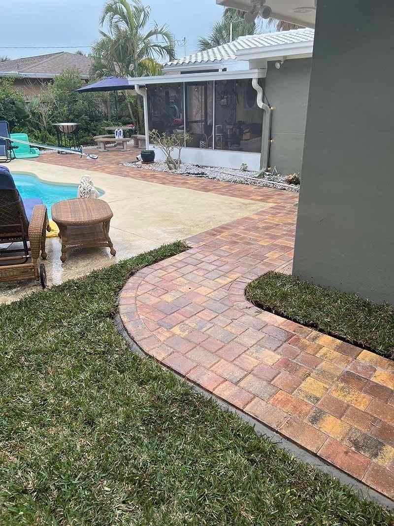 Brick-tone paver pool deck with a curved border