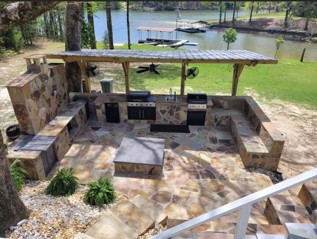 Lakefront outdoor kitchen with a flagstone patio and pergola