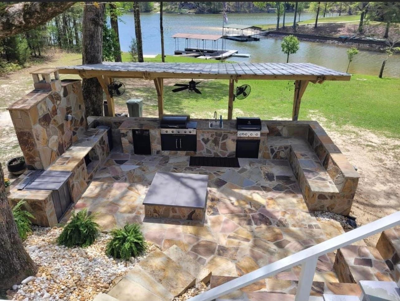 Lakefront outdoor kitchen with a flagstone patio and pergola